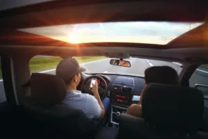 two people in car one looking at mobile