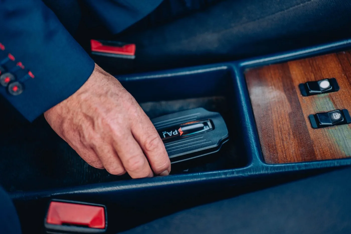 a hand placing gps tacker on car
