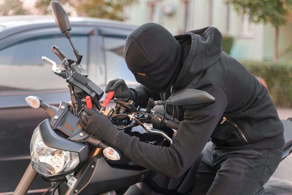 a thief trying to steal motorbike. but GPS tracker prevent car and bike theft