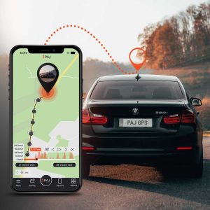 A black car on road and on its side a mobile running paj finder portal application with hidden GPS tracking device for cars