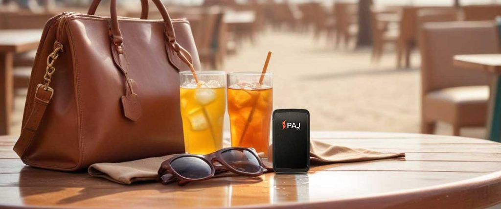 paj waterproof gps tracker on top of table with bag and cool drinks.